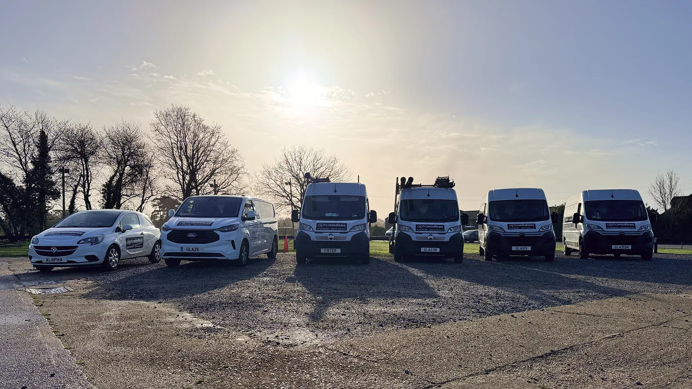Six Alpha Windows branded vehicles parked together in a field in South Buckinghamshire