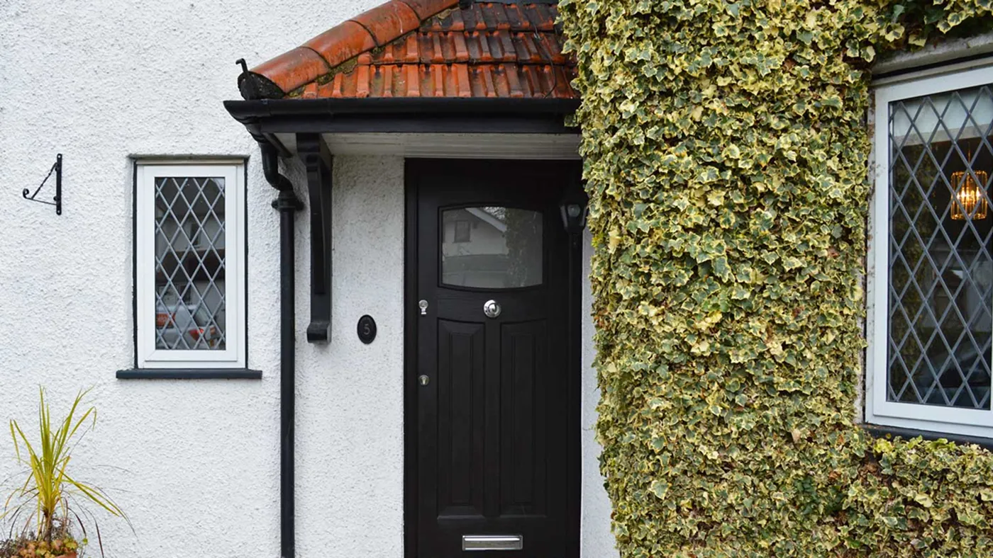 Black composite door fitted to white rendered cottage, Fulmer