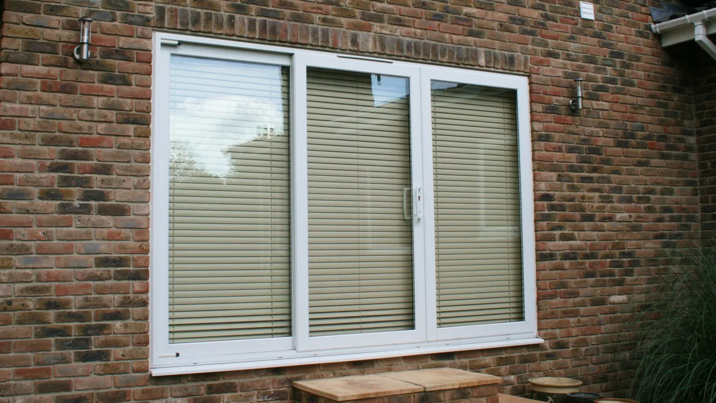 White uPVC three-pane sliding patio doors on brick property, Beaconsfield