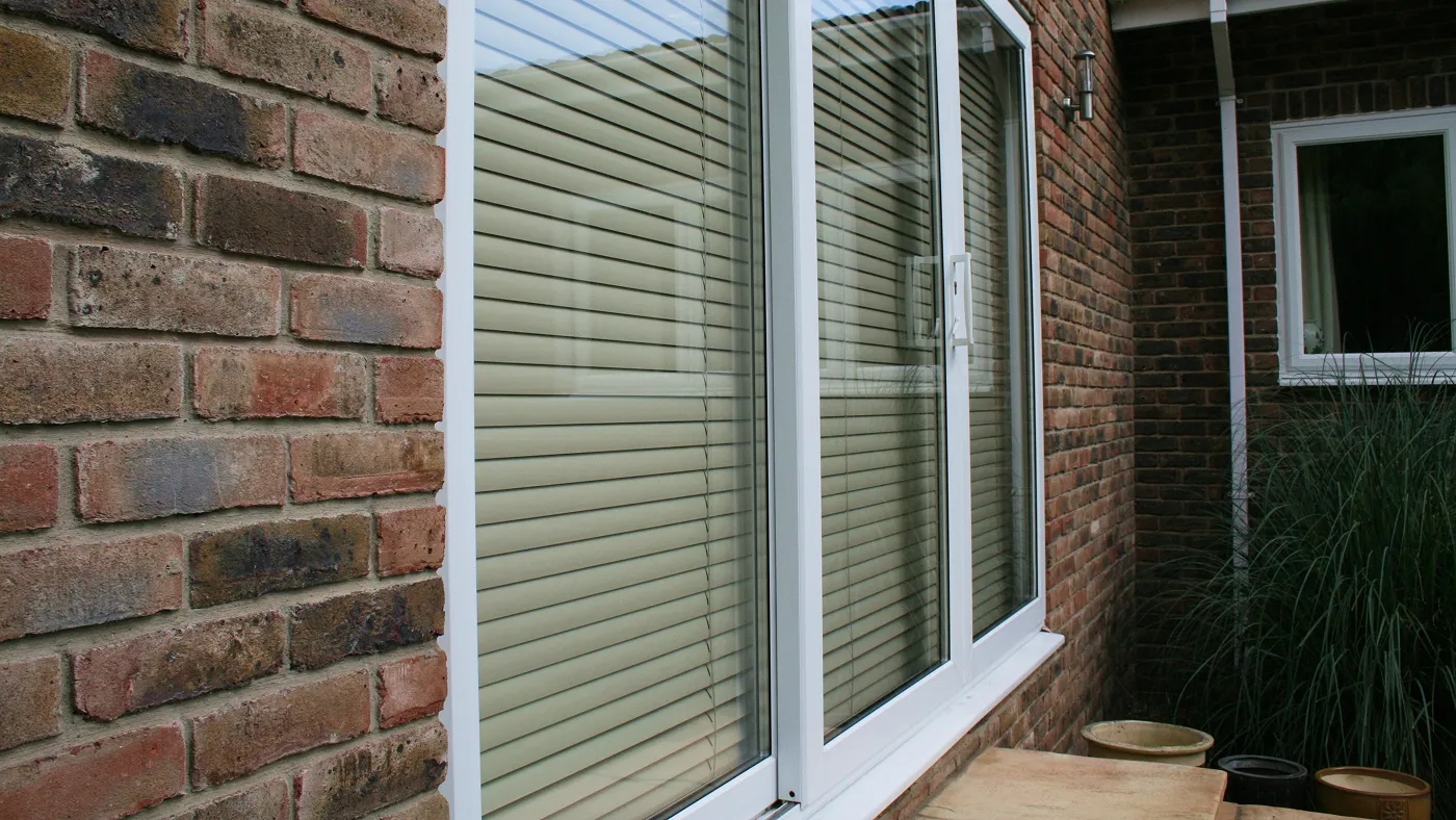 White uPVC three-pane sliding patio doors on brick property, Beaconsfield