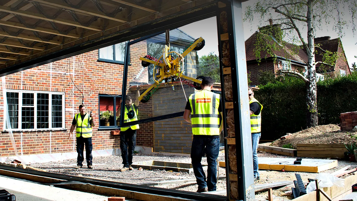 Floor to ceiling glazing panels being installed by crane on a property in Gerrards Cross