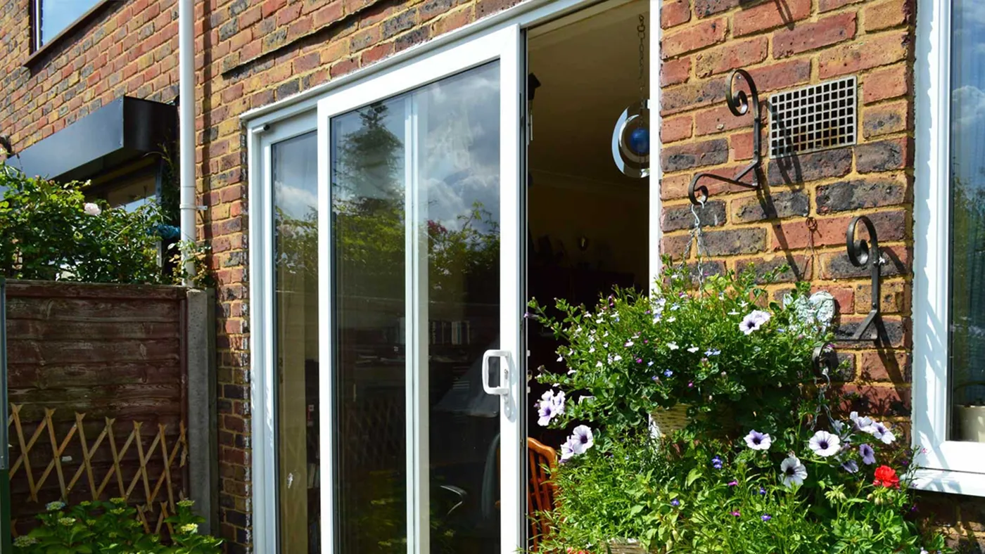 White uPVC sliding patio door with garden planting, Windsor