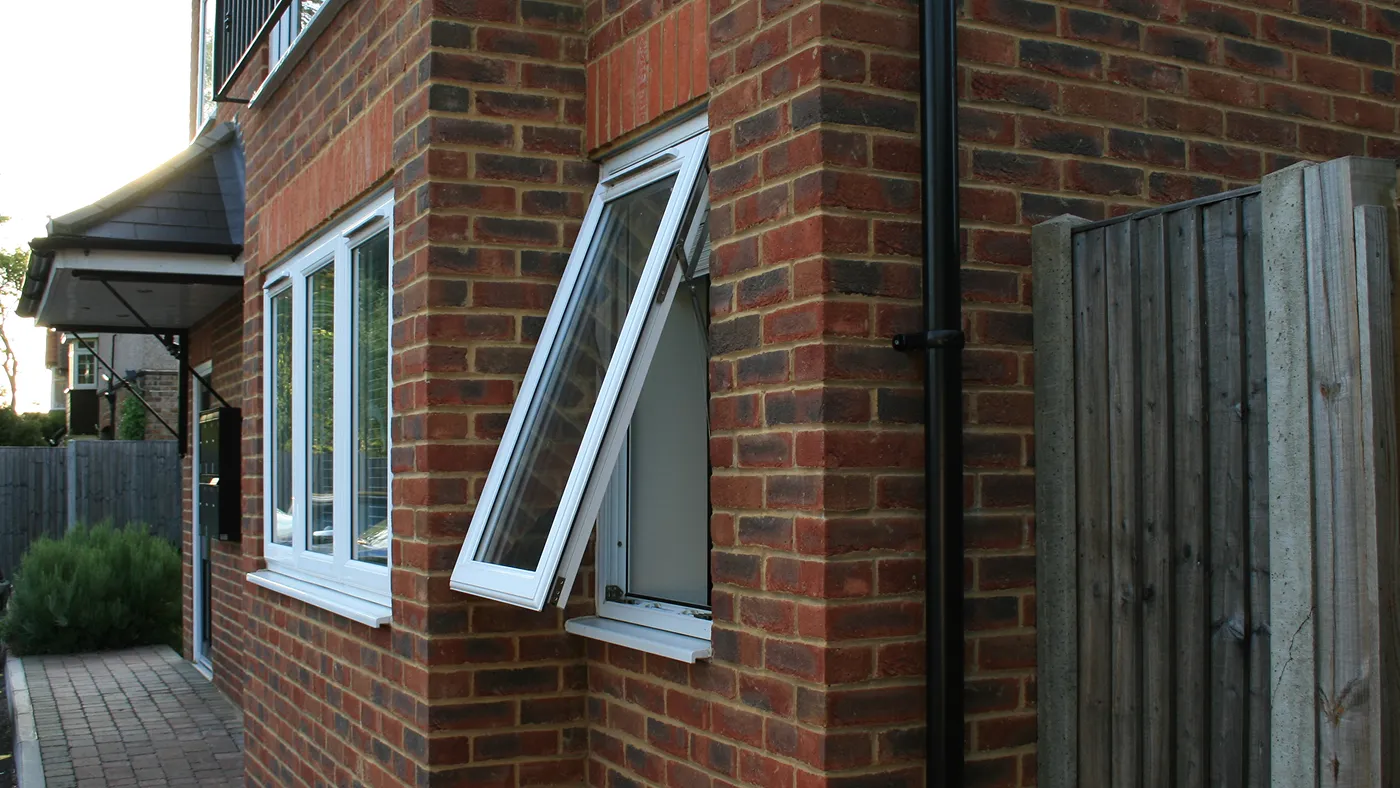 Tilt and turn window in turn position on red brick house, Denham