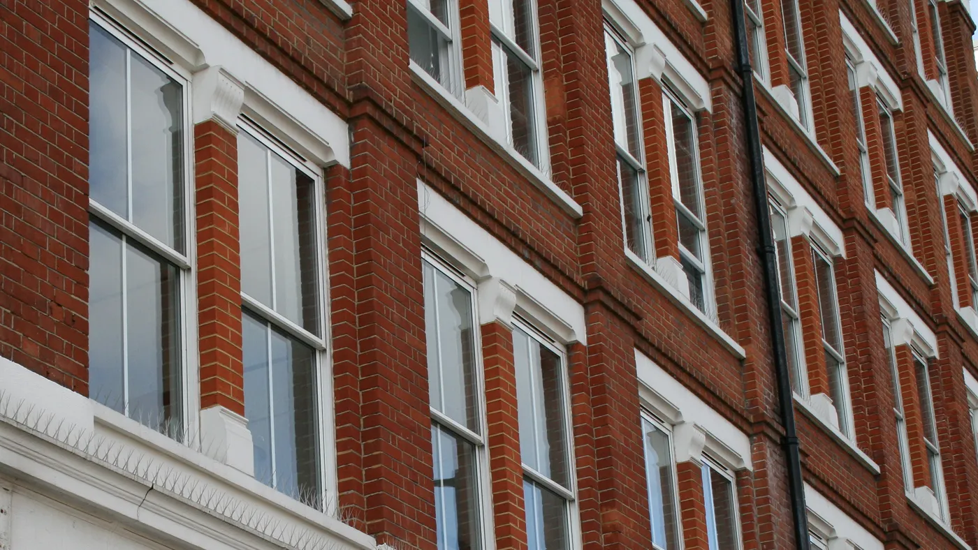 White sash windows across apartment block facade, London